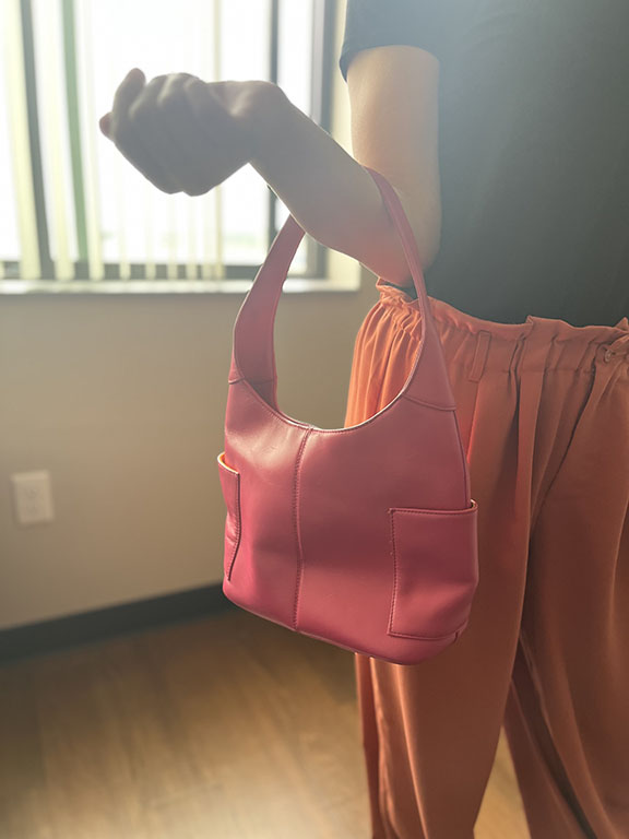 person holding pink purse on her forearm